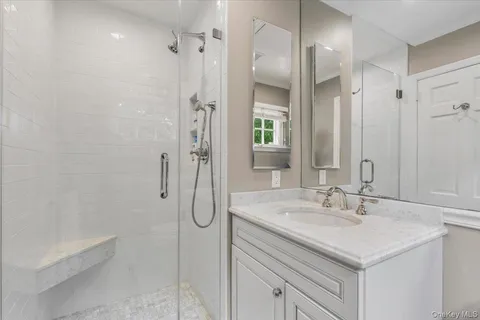 a bathroom with a shower sink and mirror