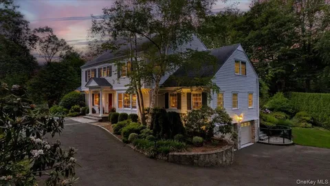 a front view of a house with a yard and potted plants