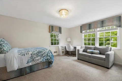 a bedroom with bed couch and window