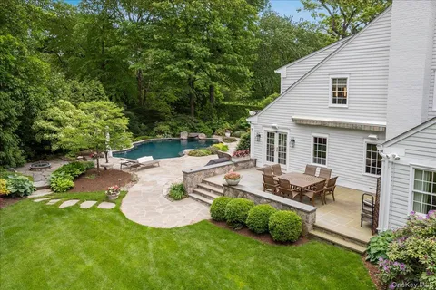 a view of a patio with table and chairs potted plants and large tree