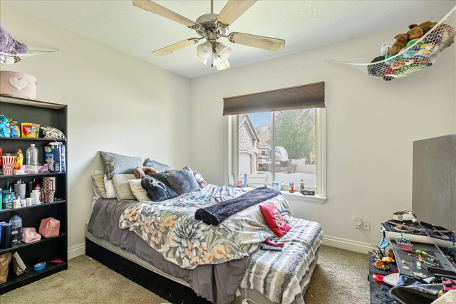 316 Azure Circle Draper, UT 84020 - Photo 26 of 48 Carpeted room featuring a window with a roller shade, a ceiling fan with light fixture, and a built-in bookshelf