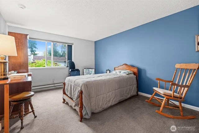 a bedroom with a bed chair and a window