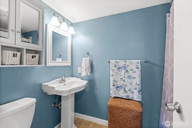a bathroom with a sink toilet and a mirror