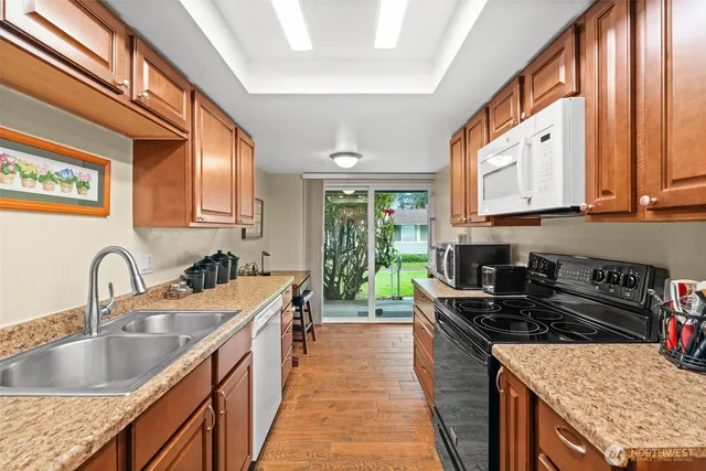 a kitchen with stainless steel appliances granite countertop a sink stove and cabinets