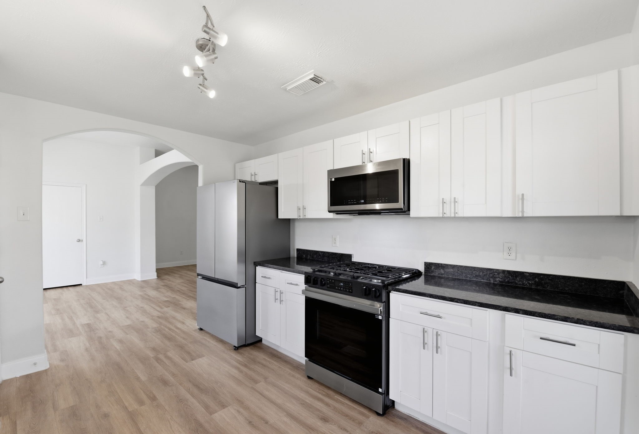 19013 Hammer Lane Porter, TX 77365 - Photo 14 of 35 a kitchen with granite countertop white cabinets and black appliances