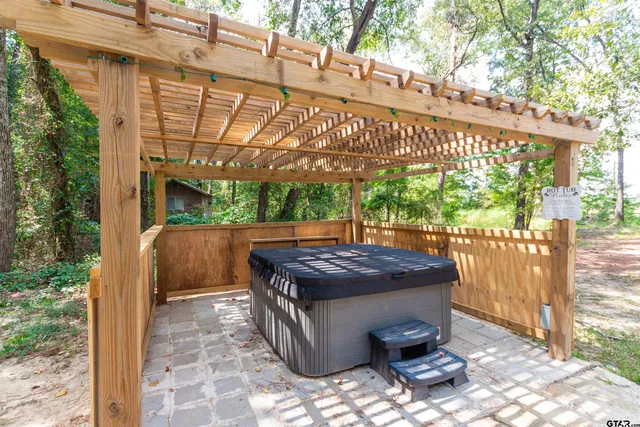 a view of a patio with table and chairs under an umbrella with a small yard
