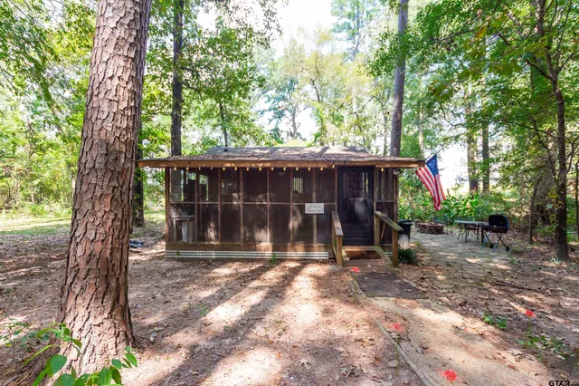 a view of a house with a yard and large tree