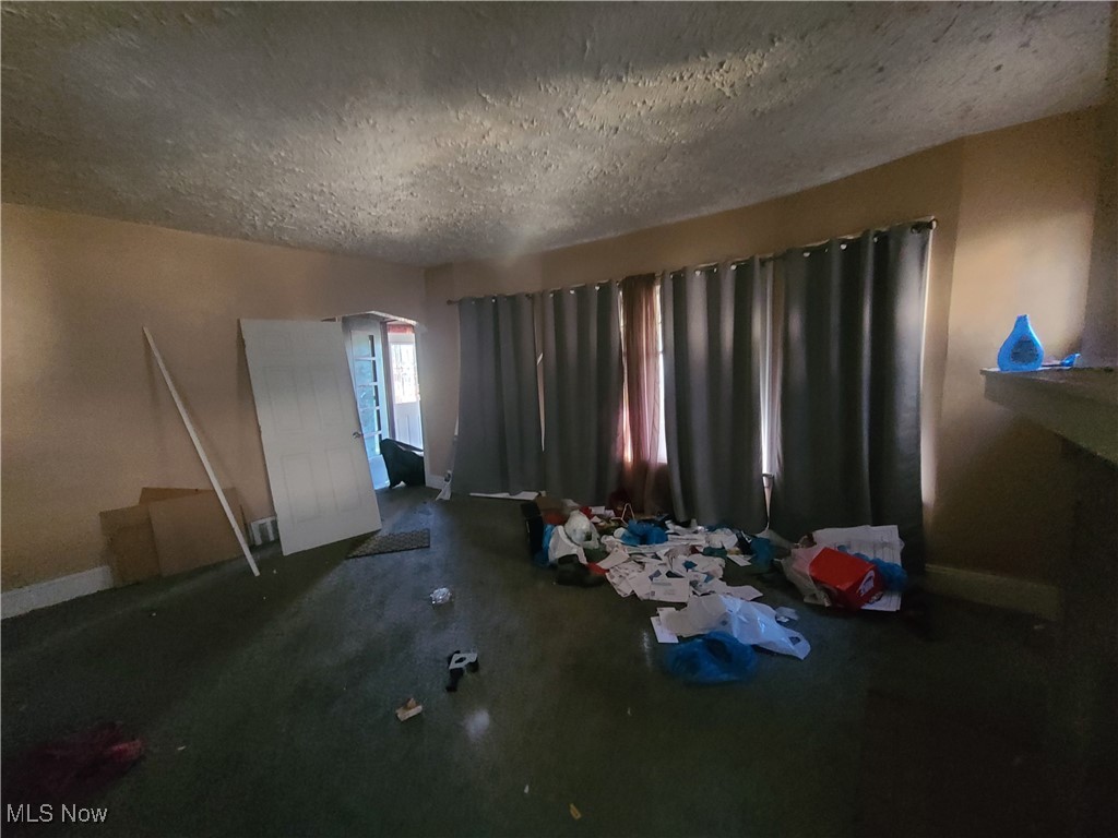 Unfurnished bedroom featuring baseboards and a textured ceiling