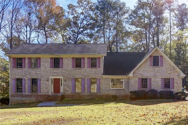 a front view of a house with a yard covered with snow