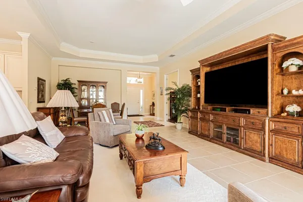 a living room with furniture a flat screen tv and a large window