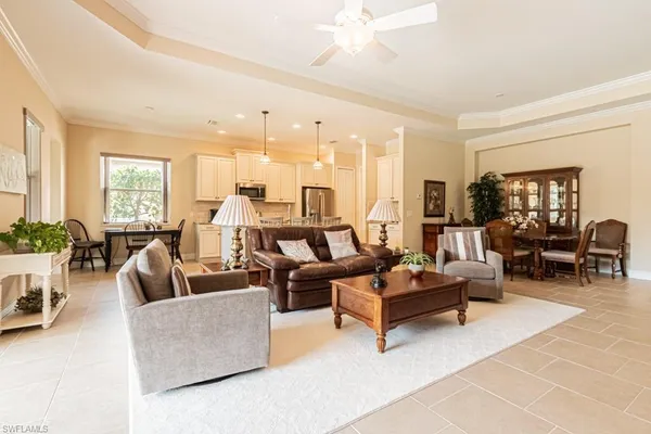 a living room with furniture kitchen view and a large window