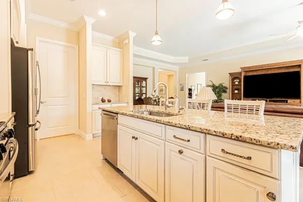 a kitchen with stainless steel appliances granite countertop a stove a refrigerator and a white cabinets