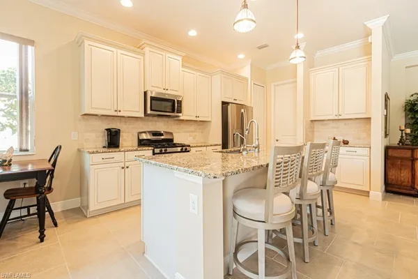 a kitchen with stainless steel appliances granite countertop a sink a stove and a refrigerator