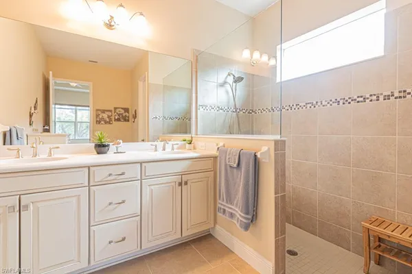 a bathroom with a double vanity sink a mirror and a bathtub