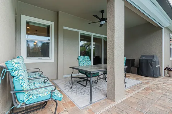 a view of a white house next to a yard with potted plants