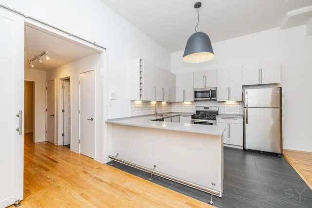 a hallway with wooden floor and cabinet