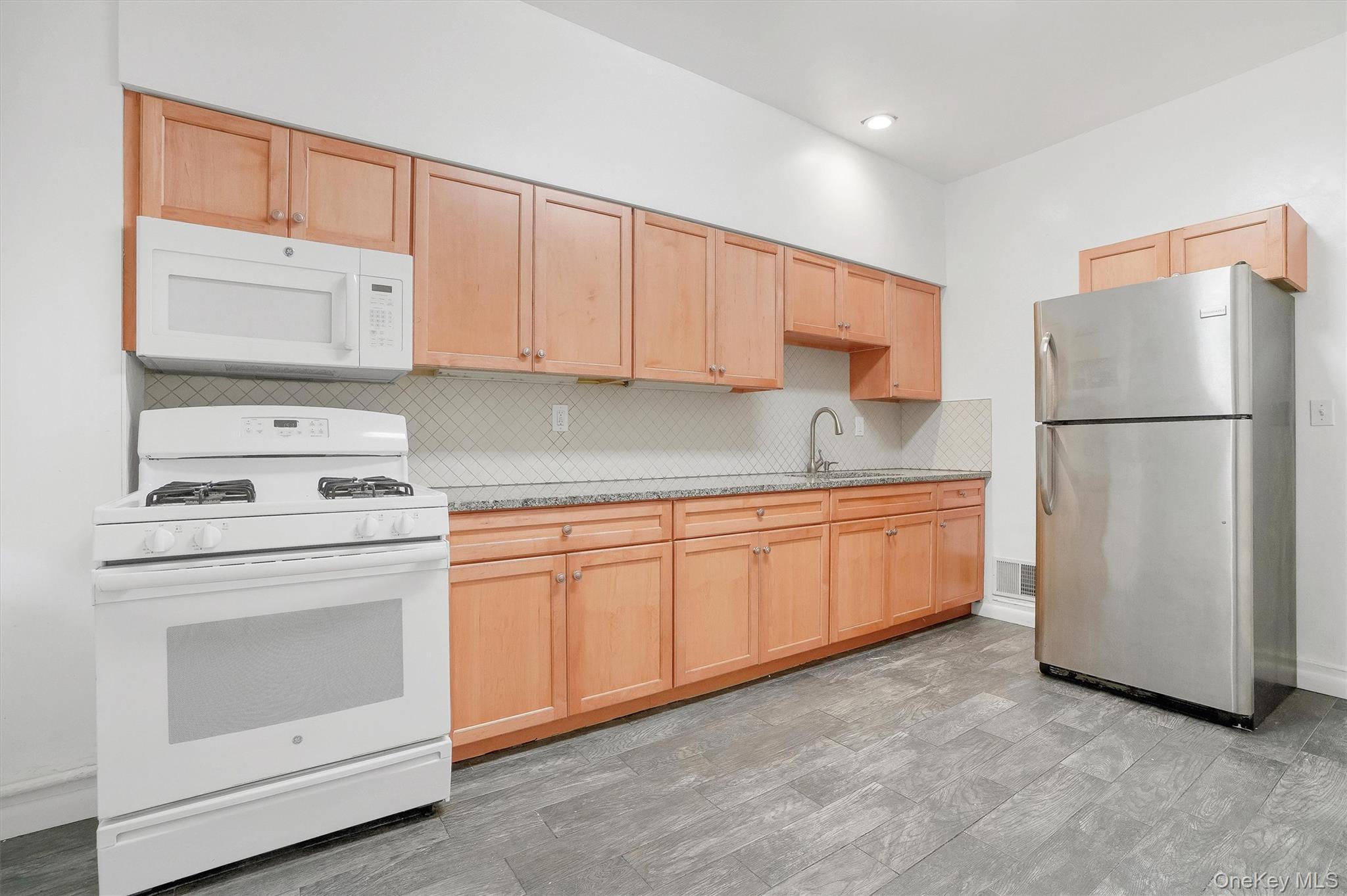 357 Dyckman Street Peekskill, NY 10566 - Photo 16 of 48 a kitchen with a white stove refrigerator and cabinets