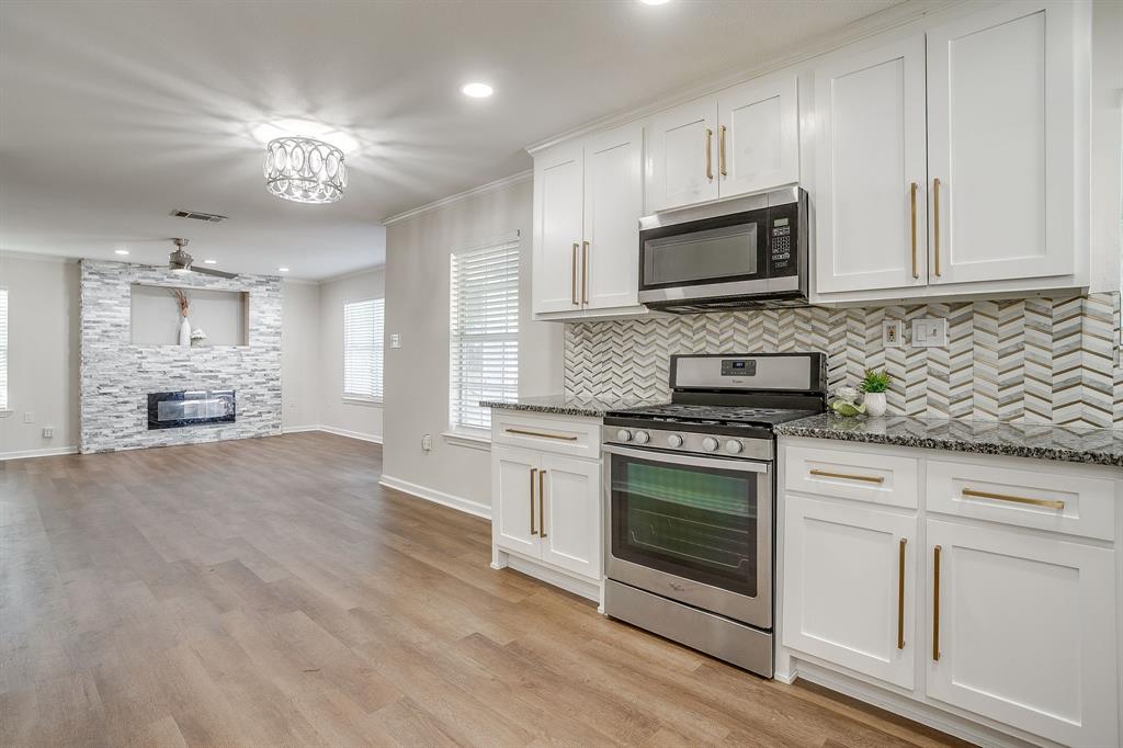2725 Halbert Street Fort Worth, TX 76112 - Photo 2 of 15 Kitchen featuring ornamental molding, stainless steel appliances, white cabinetry, granite counters, and decorative backsplash