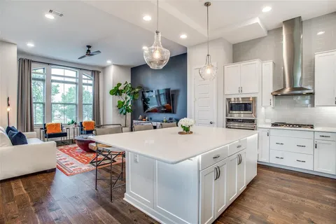 a large white kitchen with lots of counter space and stainless steel appliances