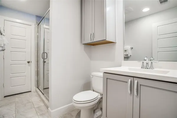 a bathroom with a granite countertop sink toilet and shower