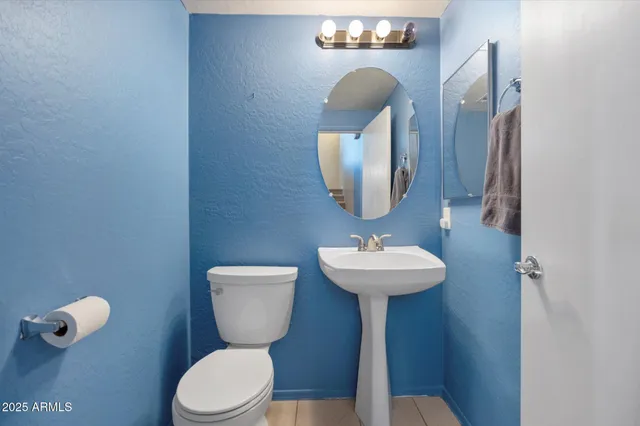 a bathroom with a toilet a sink and mirror