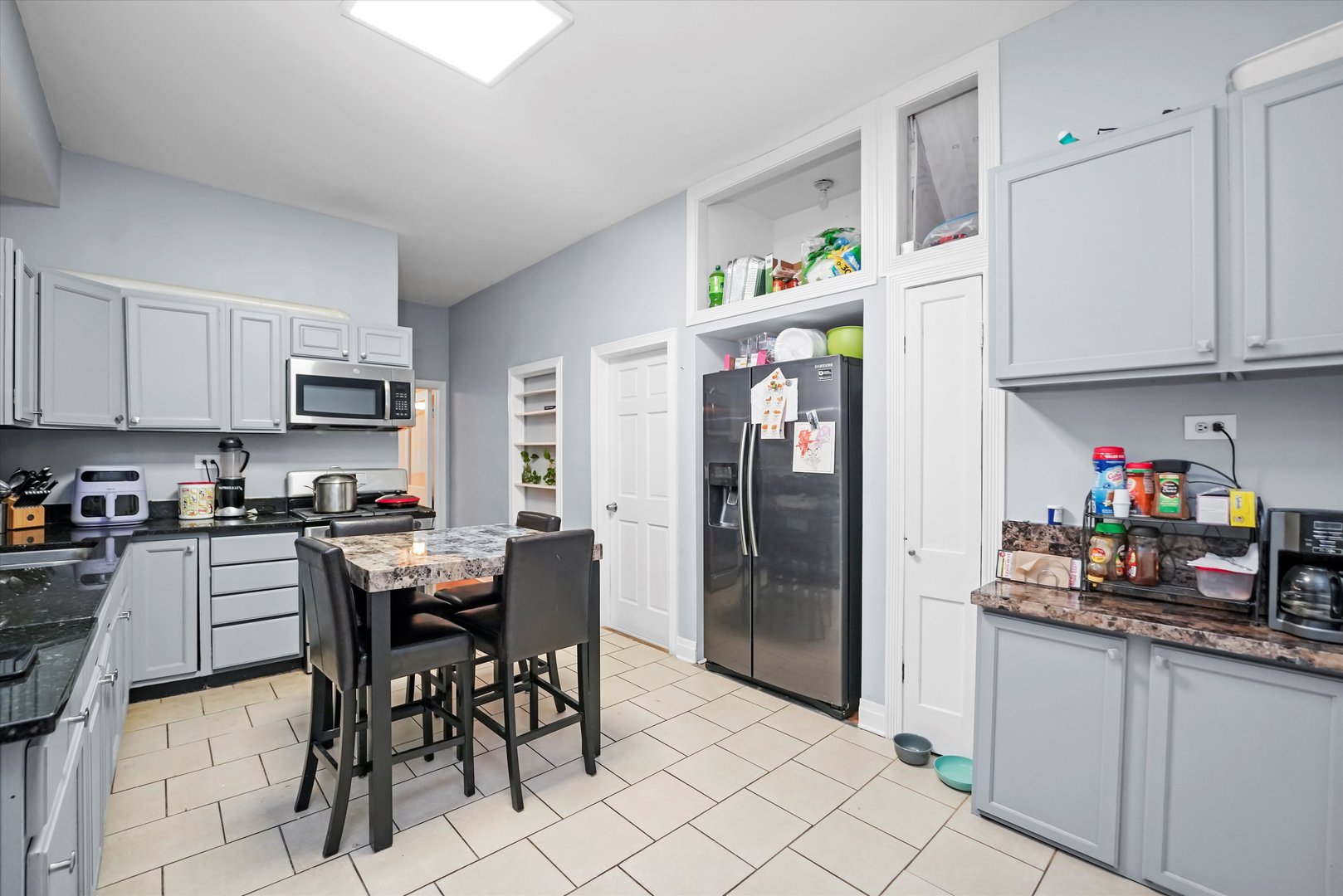 2713 West 24th Place Chicago, IL 60608 - Photo 8 of 31 a kitchen with stainless steel appliances granite countertop a refrigerator and a stove top oven