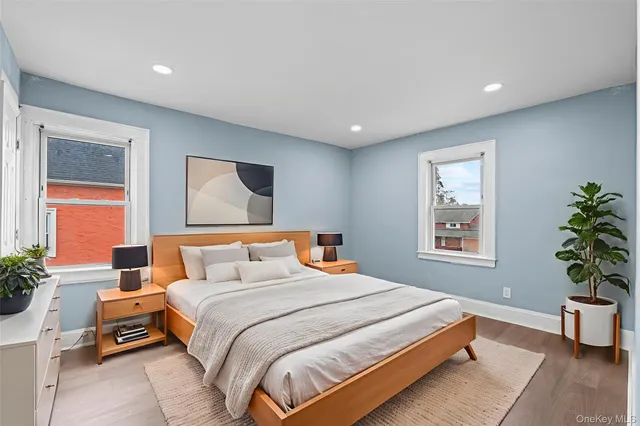 a bedroom with a large bed and a potted plant