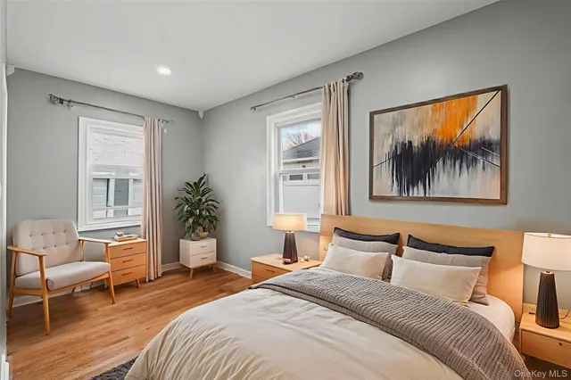 a bedroom with a bed a couch and potted plant on the dresser