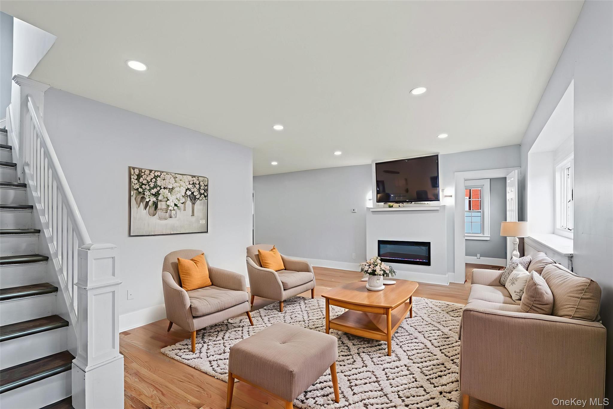 28 Cornwall Lane Hempstead, NY 11550 - Photo 14 of 20 a living room with furniture a fireplace and a flat screen tv
