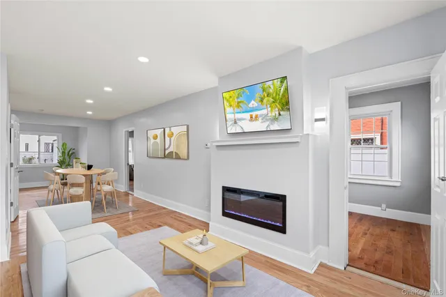 a living room with furniture a flat screen tv and a fireplace
