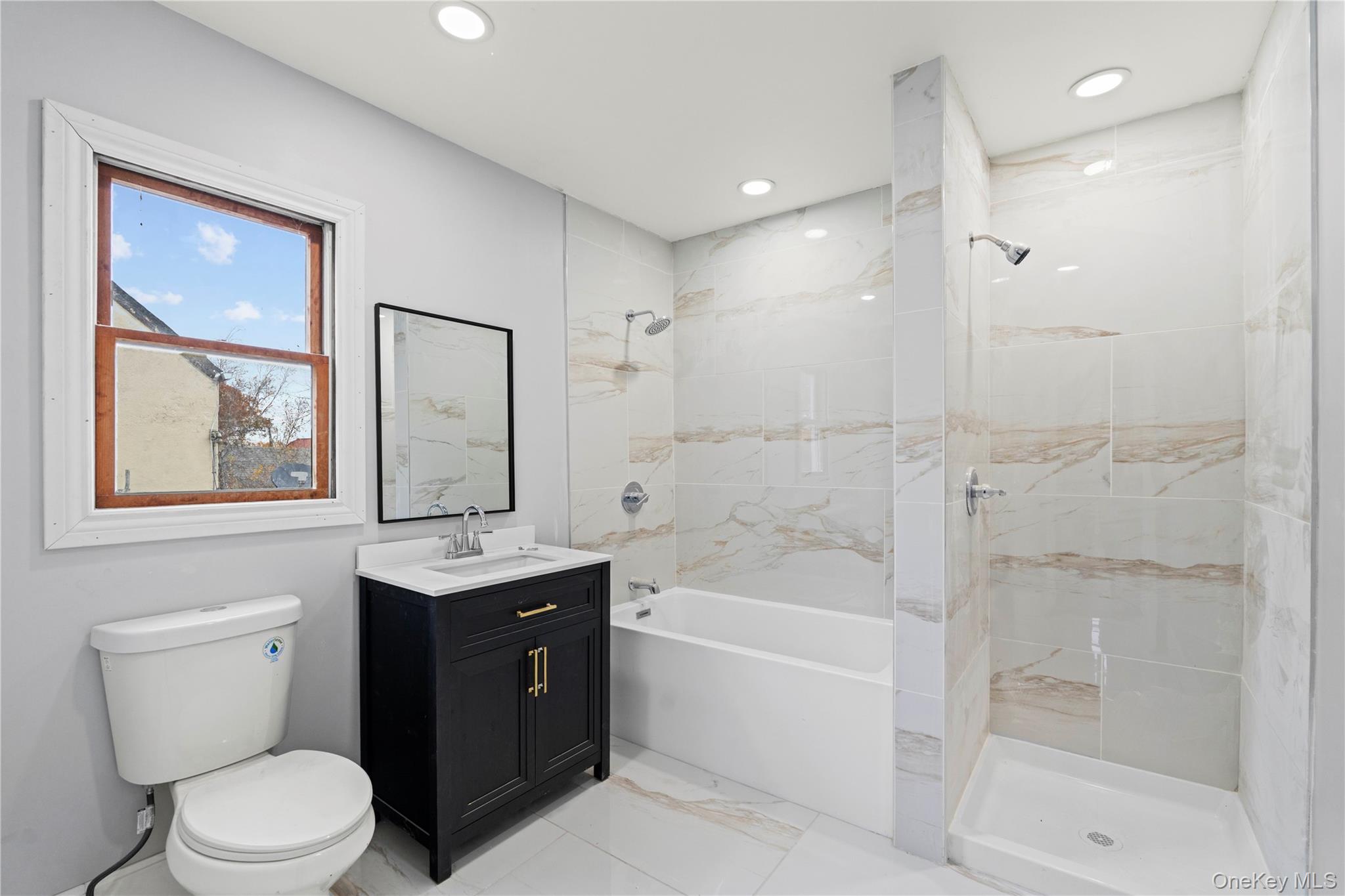 28 Cornwall Lane Hempstead, NY 11550 - Photo 6 of 20 a bathroom with a sink a toilet and shower