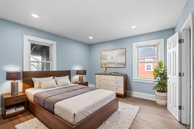 a bedroom with a large bed and a potted plant