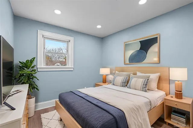 a bedroom with a large bed and a potted plant