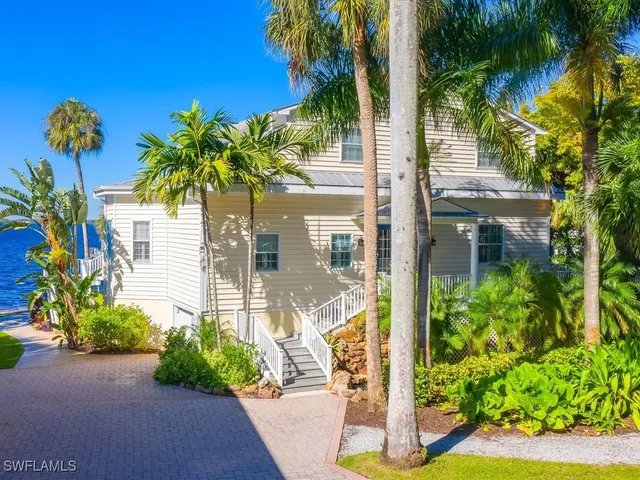 a front view of a house with a yard and garden