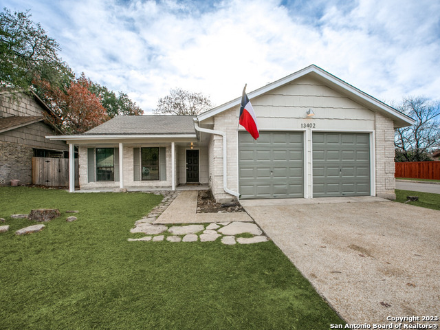 a front view of a house with a garden and yard