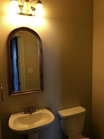 a bathroom with a toilet sink and mirror