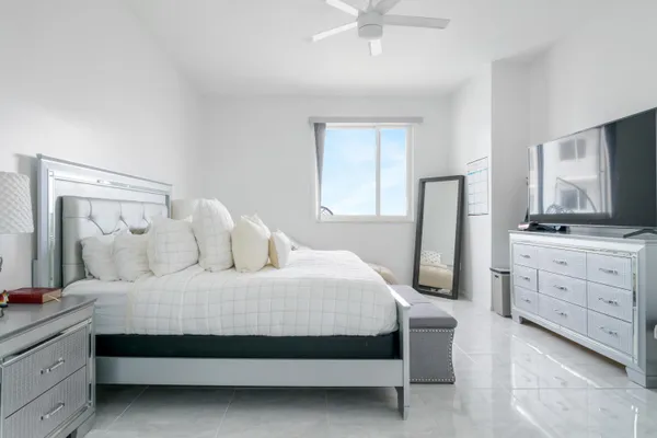 a bedroom with a bed and a flat tv screen on dresser