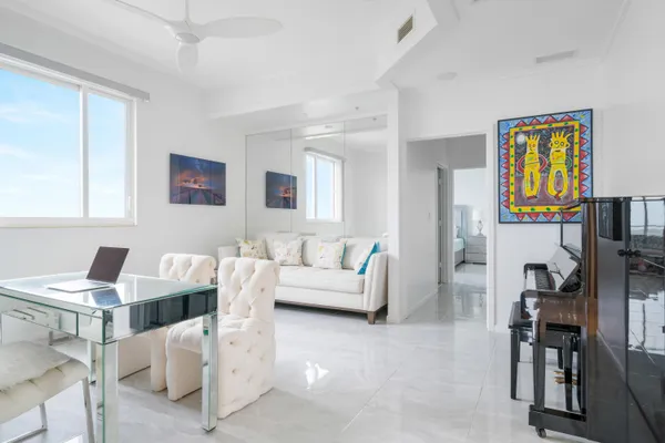 a living room with furniture and paintings on the wall