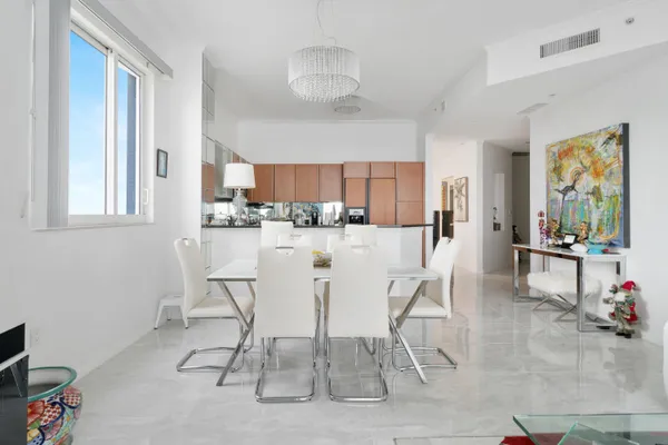 a dining room with stainless steel appliances a table and chairs in it
