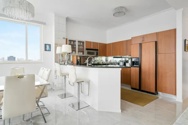 a kitchen with stainless steel appliances kitchen island granite countertop a refrigerator and a cabinets