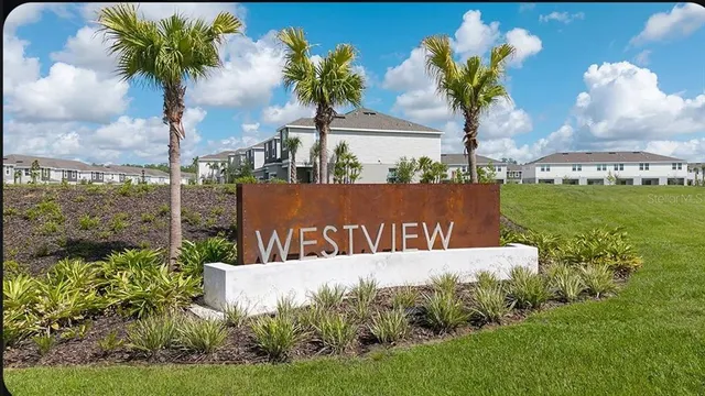 a sign that is sitting in the grass next to a road