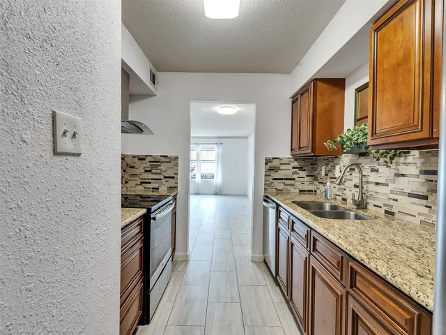 a kitchen with stainless steel appliances granite countertop a stove and a sink