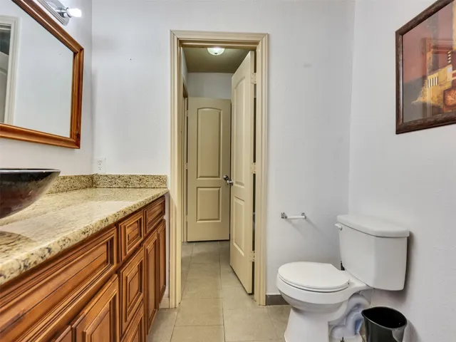 a bathroom with a granite countertop toilet sink and mirror