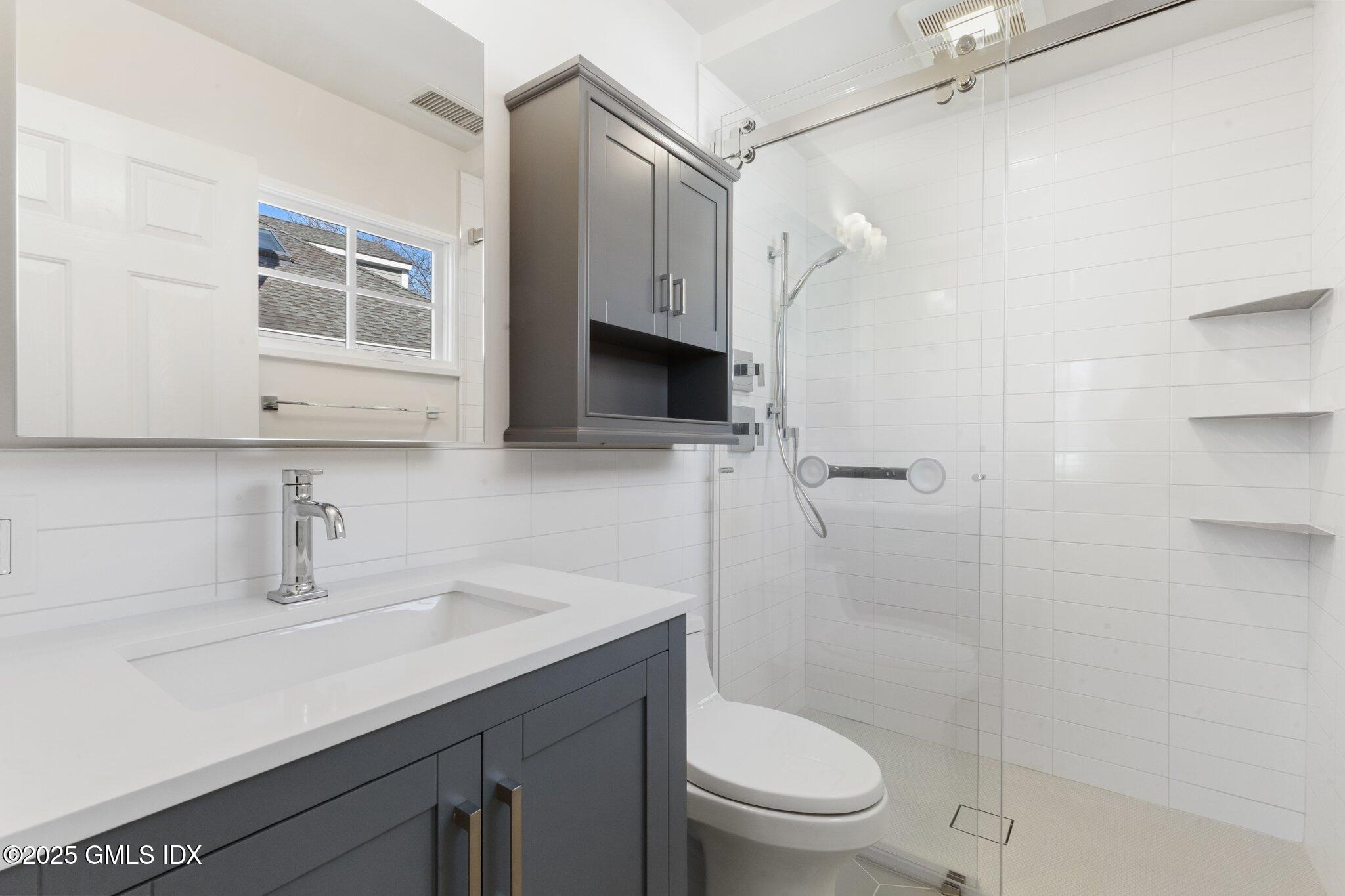 84 Indian Harbor Drive Greenwich, CT 06830 - Photo 12 of 16 a bathroom with a sink a toilet and shower