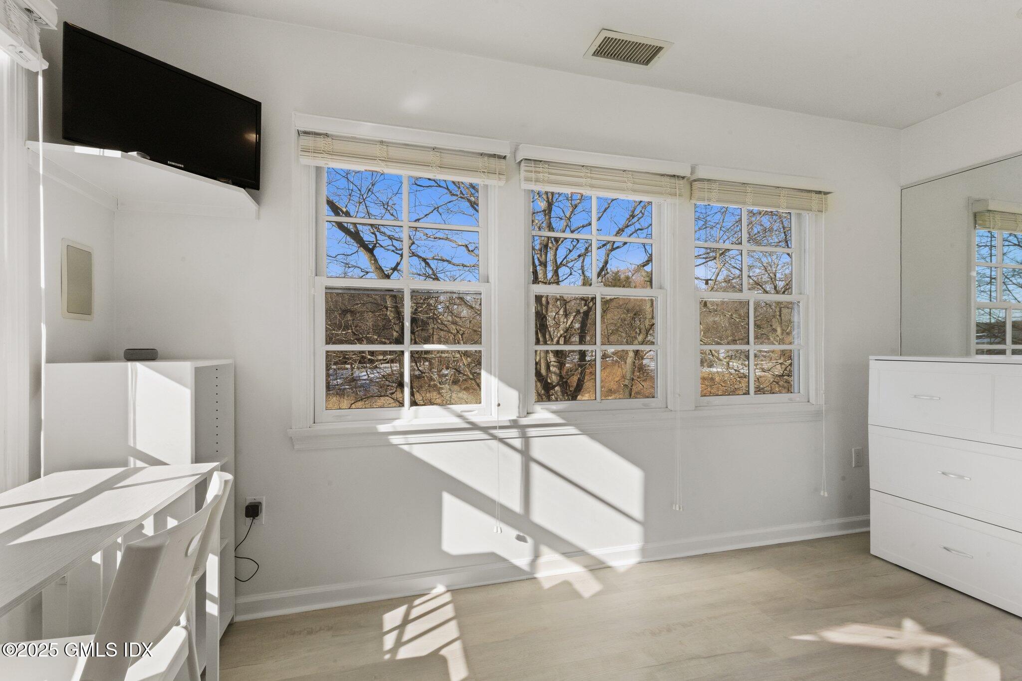 84 Indian Harbor Drive Greenwich, CT 06830 - Photo 9 of 16 a room with a bed and a large window