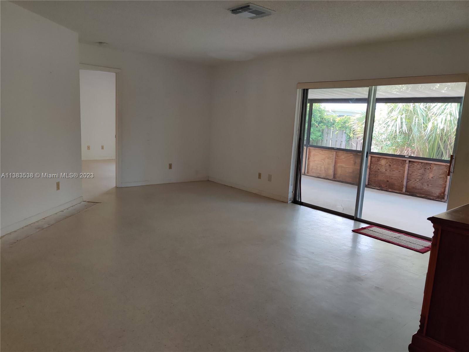 141 Arrowhead Circle Jupiter, FL 33458 - Photo 5 of 25 an empty room with wooden floor and windows