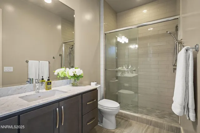 a bathroom with a sink a toilet and shower