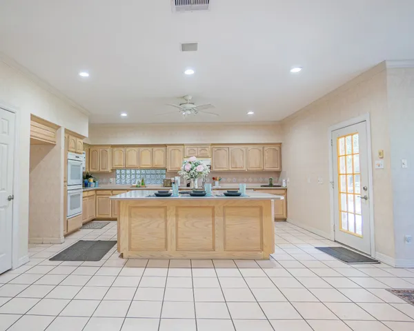 a kitchen with cabinets and chairs
