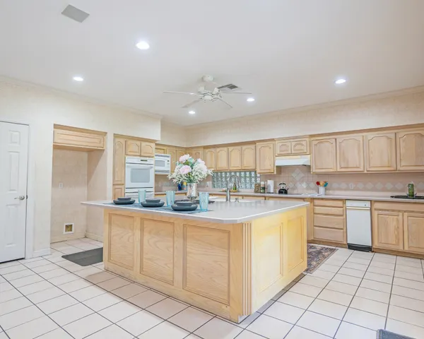 a kitchen with a sink dishwasher stove and white cabinets with wooden floor