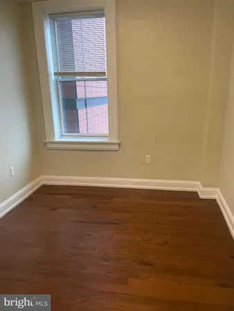 a view of a room with wooden floor and a window